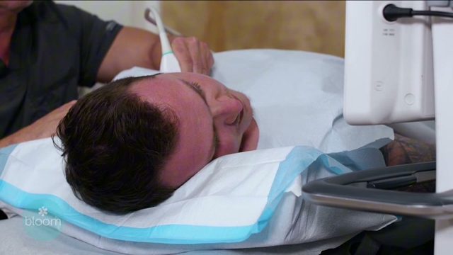 The ultrasound probe positioned at a patient’s neck on the treatment table